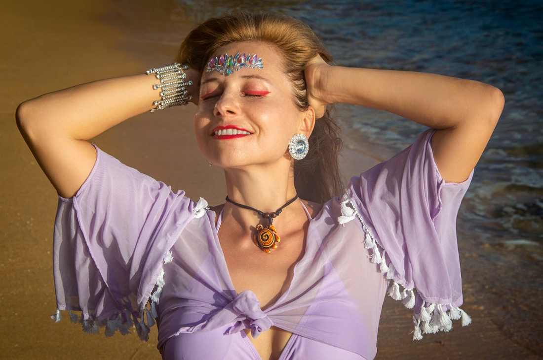 A mature woman strips down at a public beach to play football nakedly